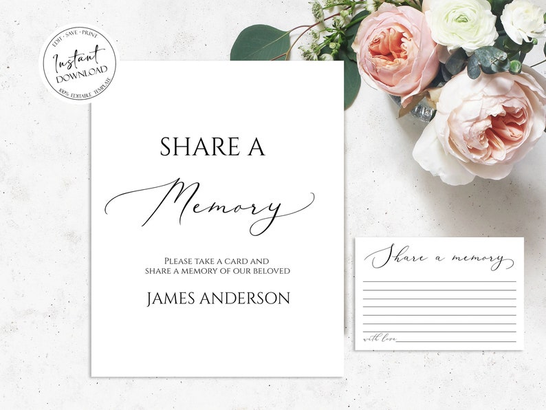 May include: A white sign with black text that reads "SHARE A Memory" and "Please take a card and share a memory of our beloved James Anderson". A smaller white card with black text that reads "Share a memory" and "with love" is to the right of the sign.