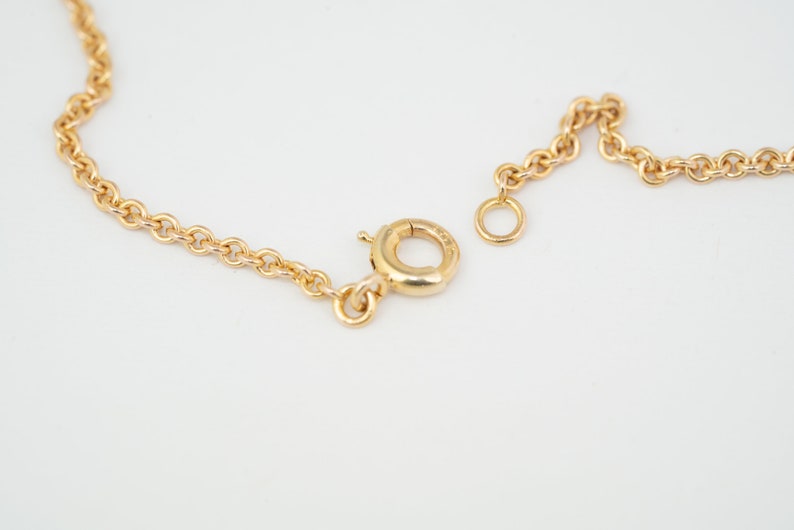May include: A gold chain necklace with a lobster clasp closure.