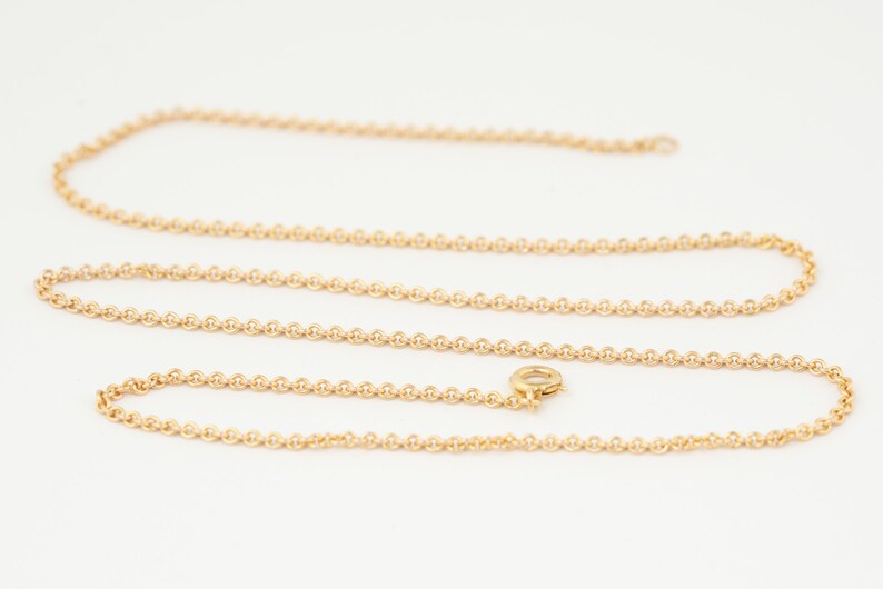 May include: A gold chain necklace with a lobster clasp.