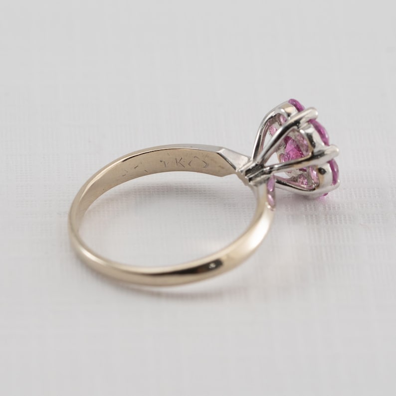 May include: A gold ring with a pink gemstone set in a prong setting. The ring is marked "14K" on the inside of the band.