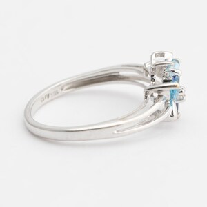 Pu&ograve; includere: Un anello d'argento con una montatura di pietra blu. L'anello ha un design delicato con una fascia leggermente pi&ugrave; larga nella parte superiore.