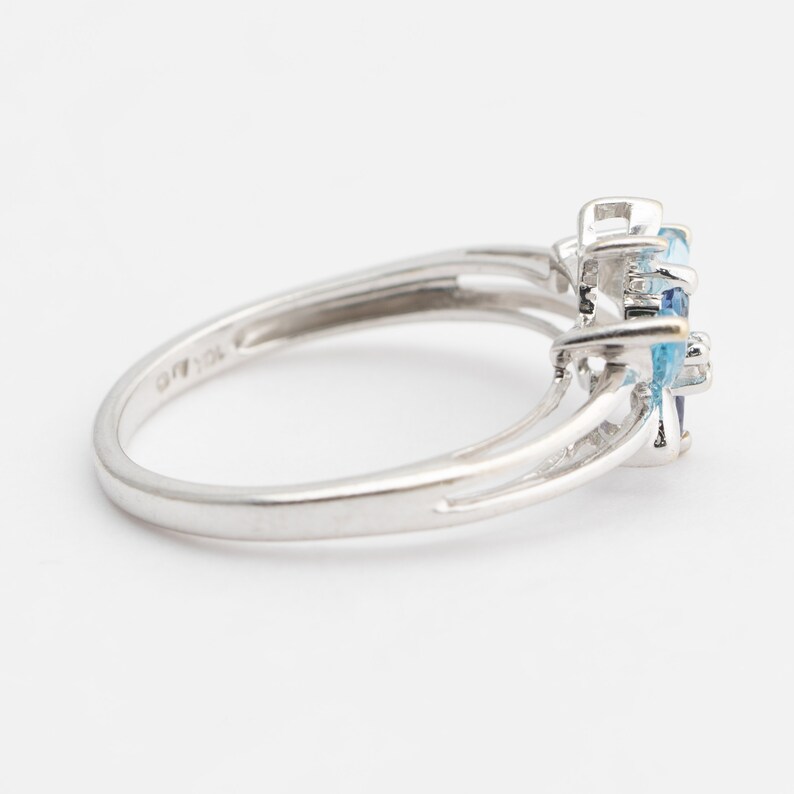 Pu&ograve; includere: Un anello d'argento con una montatura di pietra blu. L'anello ha un design delicato con una fascia leggermente pi&ugrave; larga nella parte superiore.