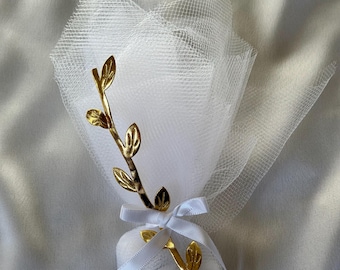 May include: A white favor bag with a gold leaf branch design, tied with a white satin ribbon. The bag is wrapped in white tulle.