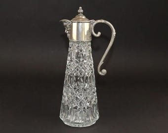 Jarra de vino tinto inglesa de estilo victoriano, bañada en plata, con máscara de Baco tallada en cristal, circa 1890-1910.