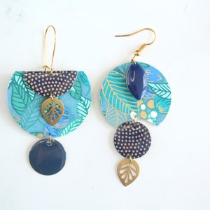 Asymmetrical Japanese leaf paper earrings on a blue background