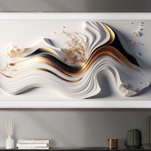 Puede incluir: Impresión de arte abstracto con un diseño blanco, dorado y negro con un patrón de capas y remolinos. La impresión está enmarcada en un marco de madera marrón claro.