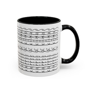 Puede incluir: Taza de cerámica blanca con interior y asa negros. El exterior presenta un patrón repetido de dibujos lineales negros, que incluyen líneas onduladas, flechas y semicírculos. La taza es para bebidas calientes.