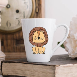 May include: White ceramic mug with a cartoon illustration of a brown lion with a yellow face. The lion is sitting down with its paws in front of it.