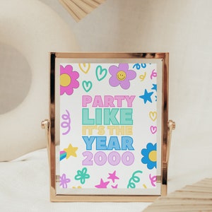 Peut inclure: Une image encadrée en or avec un fond blanc et un texte coloré qui dit "Party Like It's The Year 2000". L'arrière-plan est décoré de cœurs, d'étoiles, de fleurs et de volutes.