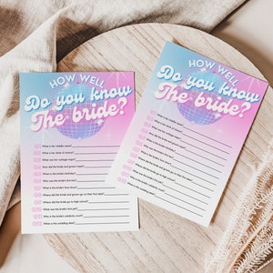 May include: Two pink and blue printable game cards with a disco ball graphic and the text "How well do you know the bride?"  The cards are designed for a bridal shower or bachelorette party.