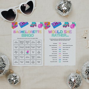 May include: Two printable game cards for a bachelorette party. The first card is a bingo card with tasks like "Get a free drink" and "Dance with a stranger". The second card is a "Would She Rather..." card with questions like "Eat pizza or eat tacos?" and "Sing karaoke or have a dance off?"