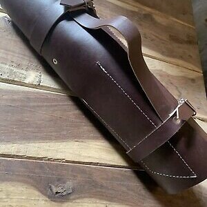May include: A brown leather roll-up case with a strap and buckle closure. The case is made of a thick, durable leather and has a stitched design.