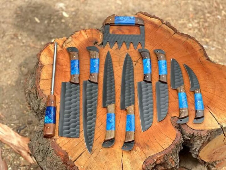 May include: A set of eight knives with blue and brown handles on a wooden surface. The knives have black blades with a textured pattern.