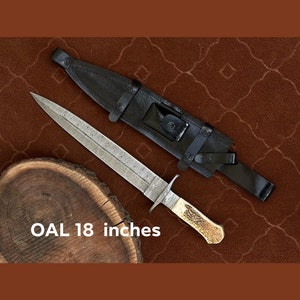 K&ouml;nnte beinhalten: Ein silbernes Messer mit einer gemusterten Klinge und einem braunen Griff. Das Messer ist 45,7 cm lang und wird mit einer schwarzen Lederscheide geliefert.