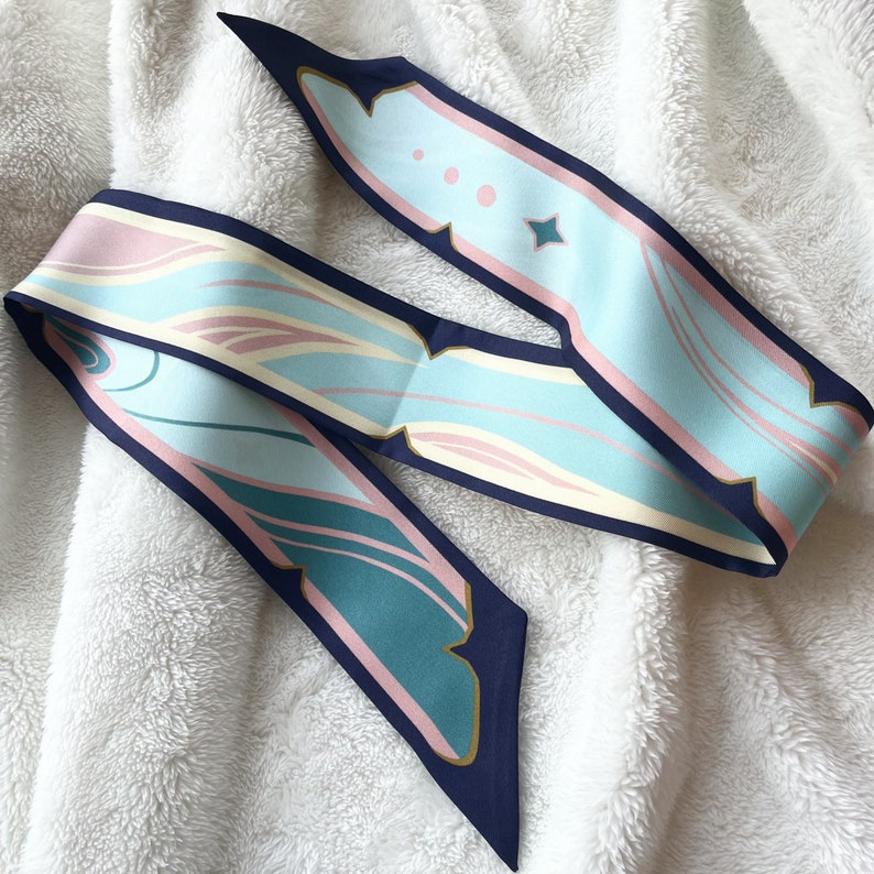 May include: A blue and pink patterned silk scarf with a navy blue trim. The scarf has a geometric design with swirls and lines.