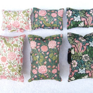 May include: Six decorative cushions with floral patterns. The cushions are made of fabric with a green background and pink flowers. The cushions are all different sizes and shapes.