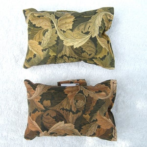 May include: Two rectangular cushions with a leafy pattern in shades of brown and green. The cushions are made of a soft, textured fabric.
