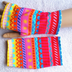 May include: A pair of colorful fingerless gloves with a geometric pattern in shades of pink, orange, yellow, blue, and green.