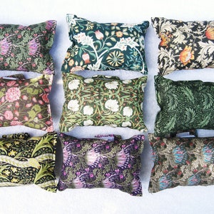 May include: Nine decorative cushions with floral patterns in shades of green, brown, pink, white, and purple. The cushions are arranged in three rows of three.