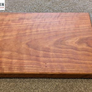 May include: A rectangular wooden chopping board with a smooth, polished surface featuring a prominent reddish-brown wood grain pattern. The board has straight edges and a flat top. The logo ALLINGRAIN and the text ALLINGRAIN.ETSY.COM appear in the corner.