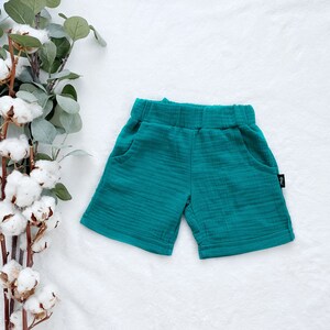 May include: Teal blue cotton shorts with a small black label on the side.