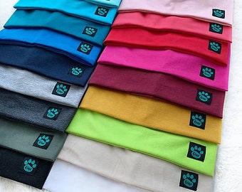 May include: A stack of 14 colourful knitted beanies with a paw print logo. The beanies are in various colours, including blue, red, pink, green, and white.