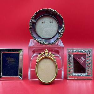 Peut inclure: Quatre cadres photo en argent plaqué, dont un avec un fond en velours rouge et le texte "Creazioni d'Arte" et un autre avec le texte "Silver Plated Photoframe".