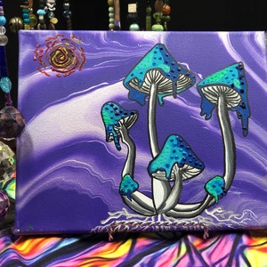 May include: A purple and white abstract background with four blue and white mushrooms with white stems and dripping blue paint. The mushrooms are painted on a canvas.