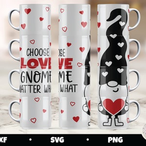 Può includere: Set di tre tazze in ceramica bianca con cuori rossi e testo nero. Le tazze sono impilate e presentano il testo "Choose Love Gnome Matter What" e "Choose Love Me What". La terza tazza presenta un gnomo nero con un cuore rosso e cuori bianchi sul suo cappello.