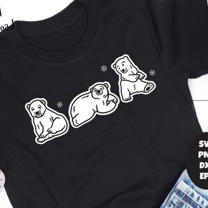 May include: A black t-shirt with a white outline of three polar bears. The bears are in different poses, one is sitting, one is lying down, and one is standing. The t-shirt has the text "Handmade Crafty Maker SVG Files" in the bottom left corner.