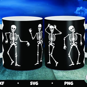 May include: Two white coffee mugs with black handles. Each mug has a black background with a white silhouette of four skeletons dancing. The skeletons are in different poses. The mugs are on a wooden surface.