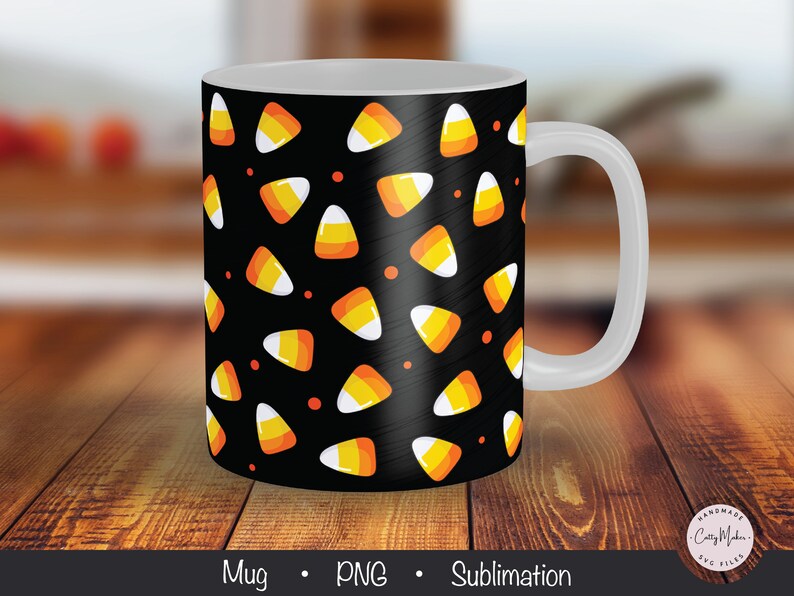May include: A white ceramic mug with a black background and a pattern of orange and yellow candy corn. The mug has a white handle.
