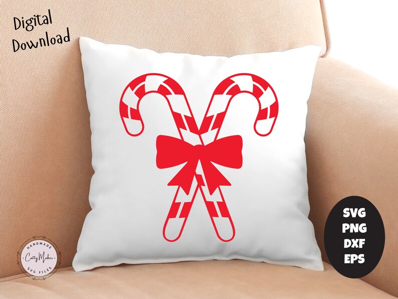 K&ouml;nnte beinhalten: Ein wei&szlig;es Kissen mit einem roten und wei&szlig;en Zuckerstangenmuster. Die Zuckerstangen sind gekreuzt und mit einer roten Schleife zusammengebunden. Das Kissen liegt auf einem beigen Sofa.