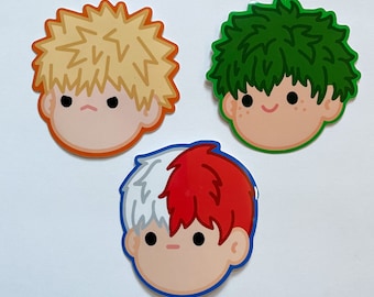May include: Three cartoon character stickers with different hair colors and facial expressions. The stickers are round and have a white outline. The first sticker has blonde hair and an angry expression. The second sticker has green hair and a happy expression. The third sticker has red and white hair and a neutral expression.