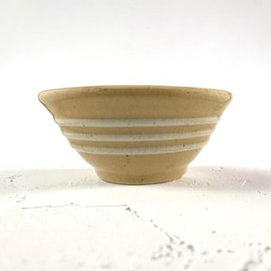 May include: A distressed white wooden sign, reading "Welcome to our home" in a handwritten font. It features a small heart detail. The background is blurred, suggesting a domestic setting. The sign is designed for indoor use.