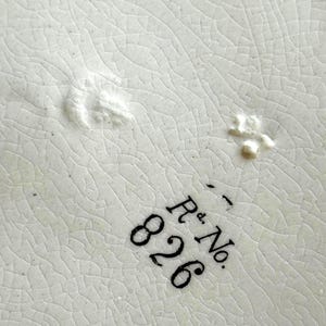 May include: Close-up of a white ceramic surface with a cracked, textured pattern. The image features the black text "R.d. No. 826" in a serif font, indicating a registered design number.