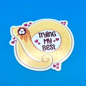 May include: A yellow cartoon snake with pink hearts around it and the text "Trying My Best" in a white circle.