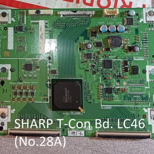 Könnte beinhalten: Eine grüne Leiterplatte mit dem aufgedruckten Text "SHARP T-Con Bd. LC46 (No.28A)". Die Platine hat mehrere elektronische Komponenten, darunter Widerstände, Kondensatoren und integrierte Schaltkreise.