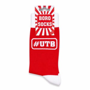 May include: Red socks with white cuffs and toes, displaying the text "#UTB" in a white box. The packaging above the socks reads "BORO SOCKS" in a red and white design. Size 6-11.