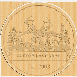 May include: A wooden sign with a deer silhouette, mountains, and trees. The sign reads "CUSTOM LAST NAME Est. 2003".