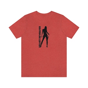 May include: Red heather t-shirt with a black silhouette of a woman holding a guitar and the text "VELVET REVOLVER" printed vertically on the left side of the shirt.