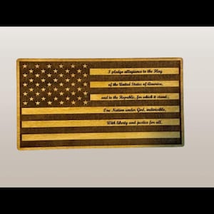 May include: A wooden plaque with a laser-engraved American flag design and the Pledge of Allegiance text. The flag is brown and black with white stars.