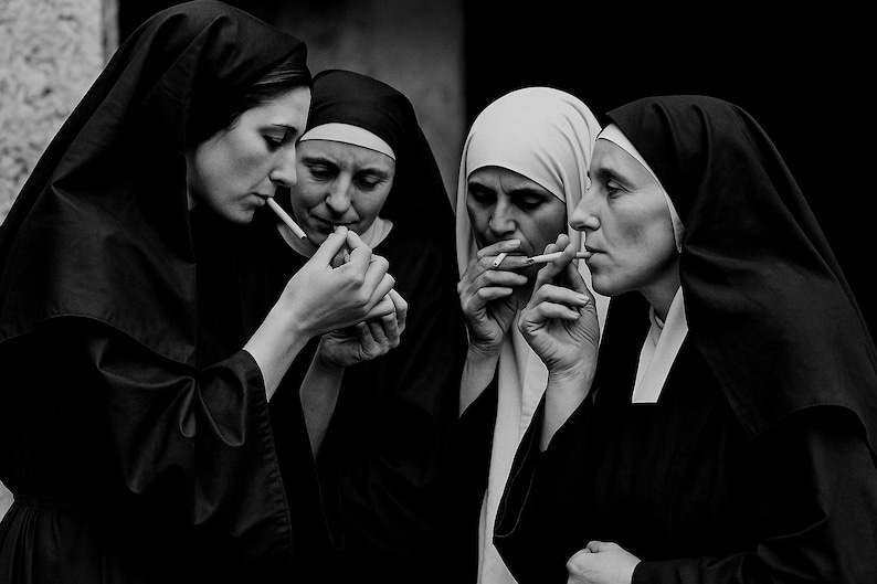 May include: A monochrome image showing four nuns in their habits, smoking cigarettes. One nun is lighting a cigarette for another. The image is a study in contrasts, with the white and black habits.