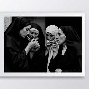 May include: A black and white photograph featuring four nuns in traditional habits, smoking cigarettes. The image is framed in a white border, with the nuns' faces and hands in focus. The nuns are in a close group, with the smoke visible.