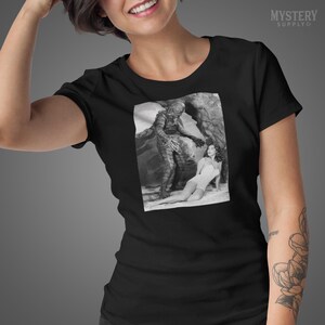 Creature from the Black Lagoon 1954 vintage horror monster Julie Adams swim suit and the gill man black and white photo Mens Womens Unisex T-Shirt from Mystery Supply Co. @mysterysupplyco