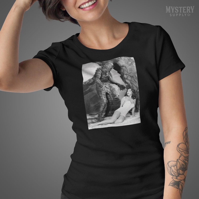 Creature from the Black Lagoon 1954 vintage horror monster Julie Adams swim suit and the gill man black and white photo Mens Womens Unisex T-Shirt from Mystery Supply Co. @mysterysupplyco