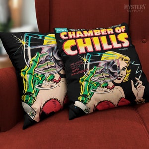 May include: Two black throw pillows with a vintage comic book cover design. The cover features a woman with a skull in a glass and the text "Chamber of Chills" in red and yellow. The text "Here's looking at you darling on our Happy Anniversary" is also on the cover.