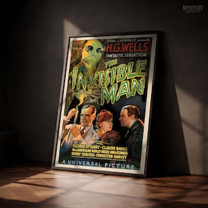 May include: A framed movie poster for The Invisible Man, featuring a large, ghostly, green-tinted face at the top and three people below. The text reads Carl Laemmle presents H.G. Wells' Fantastic Sensation The Invisible Man, A Universal Picture.