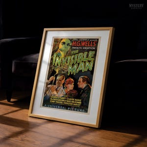 May include: A framed vintage movie poster for The Invisible Man, featuring a green-tinted figure, three actors, and bold text. The poster includes credits for Carl Laemmle, H.G. Wells, Gloria Stuart, Claude Rains, and the Universal Pictures logo.