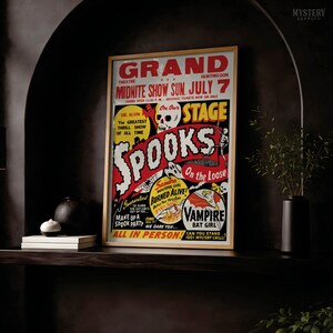 K&ouml;nnte beinhalten: Ein gerahmtes Theaterplakat im Vintage-Stil mit der Aufschrift Grand Theatre Midnite Show Sun July 7 Spooks On The Loose. Die Grafik zeigt einen Totenkopf, ein Skelett, ein Spinnennetz und Text, der eine Gruselshow mit Vampir-Fledermaus-M&auml;dchen bewirbt.